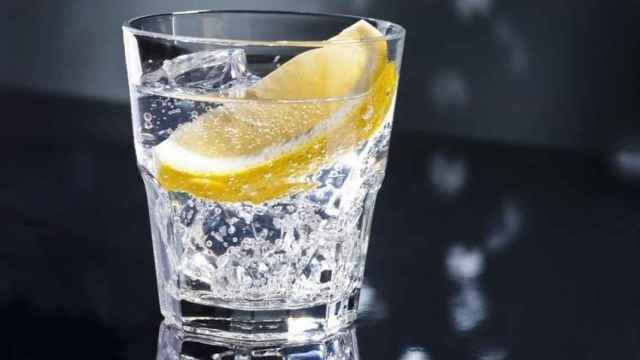 Un vaso de tónica con una rodaja de limón.