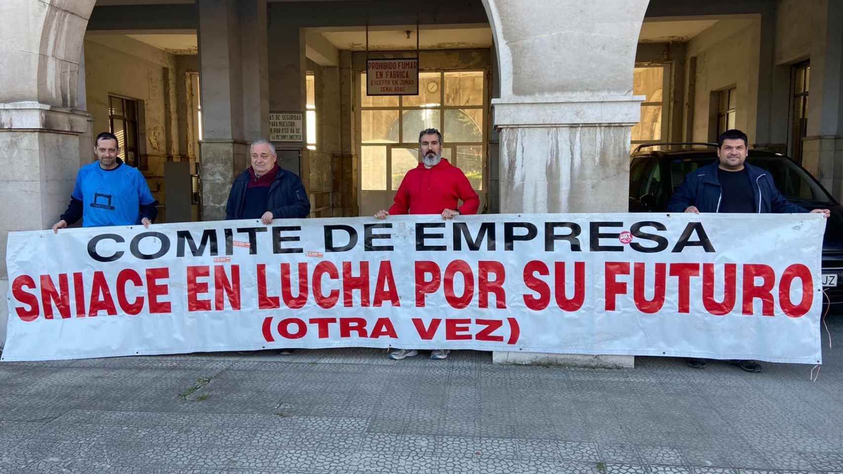 Extrabajadores de Sniace exhiben una pancarta en el centro de Torrelavega.