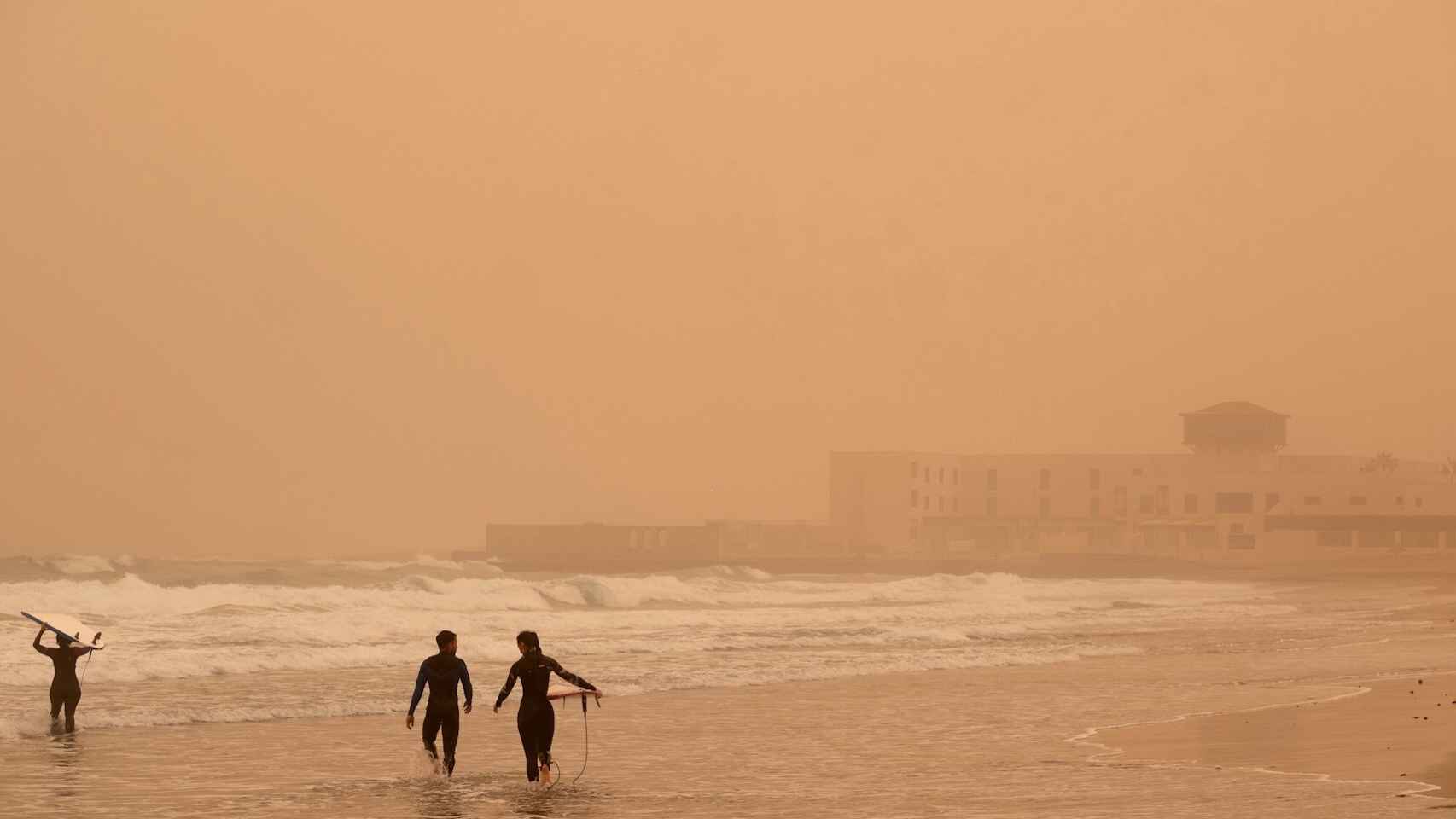 Surfistas en Puerto del Rosario (Fuerteventura) bajo la calima. EFE/Carlos de Saá.