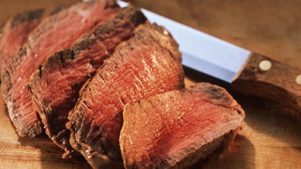 Cortes de carne roja con su jugo rojizo.