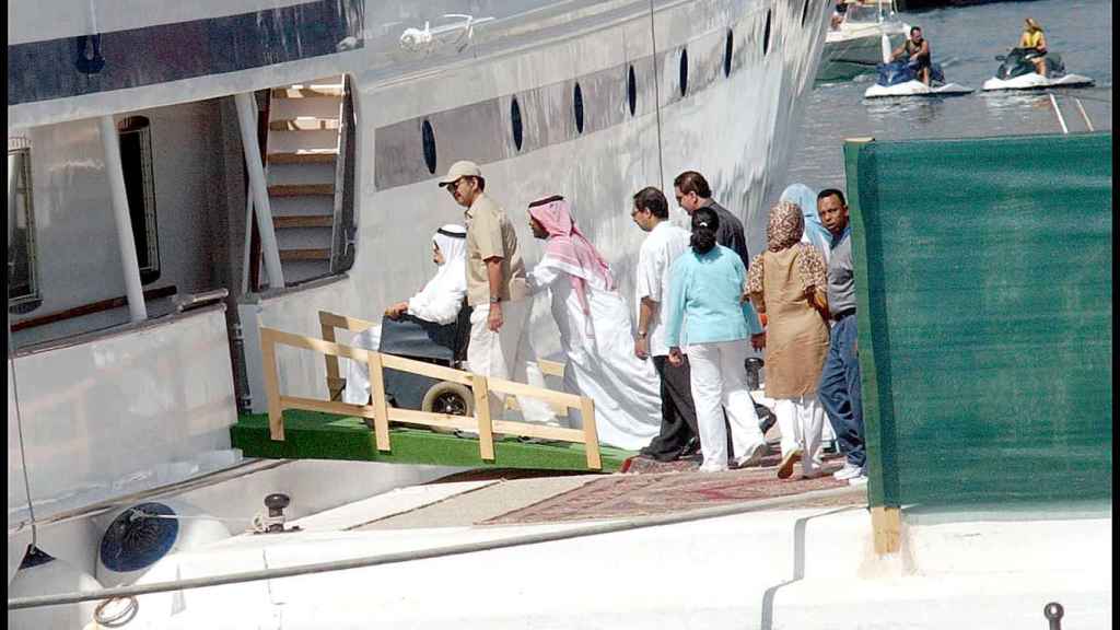 El rey Fahd de Arabia Saudí (silla de ruedas) con su comitiva subiendo abordo de su barco  Al Diriyah durante unas vacaciones en Marbella.