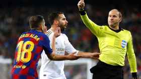 Antonio Mateu Lahoz muestra una tarjeta amarilla a Jordi Alba por una acción con Dani Carvajal
