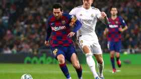 Toni Kroos intenta robar el balón a Leo Messi