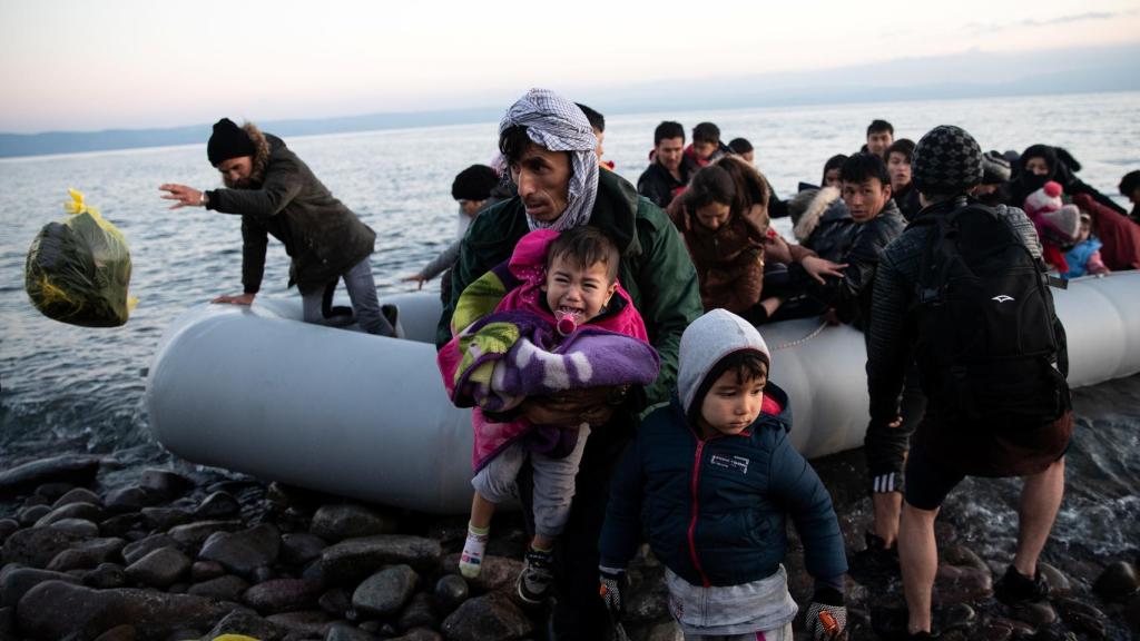Migrantes de Afganistán llegan a un bote en una playa cerca del pueblo de Skala Sikamias.
