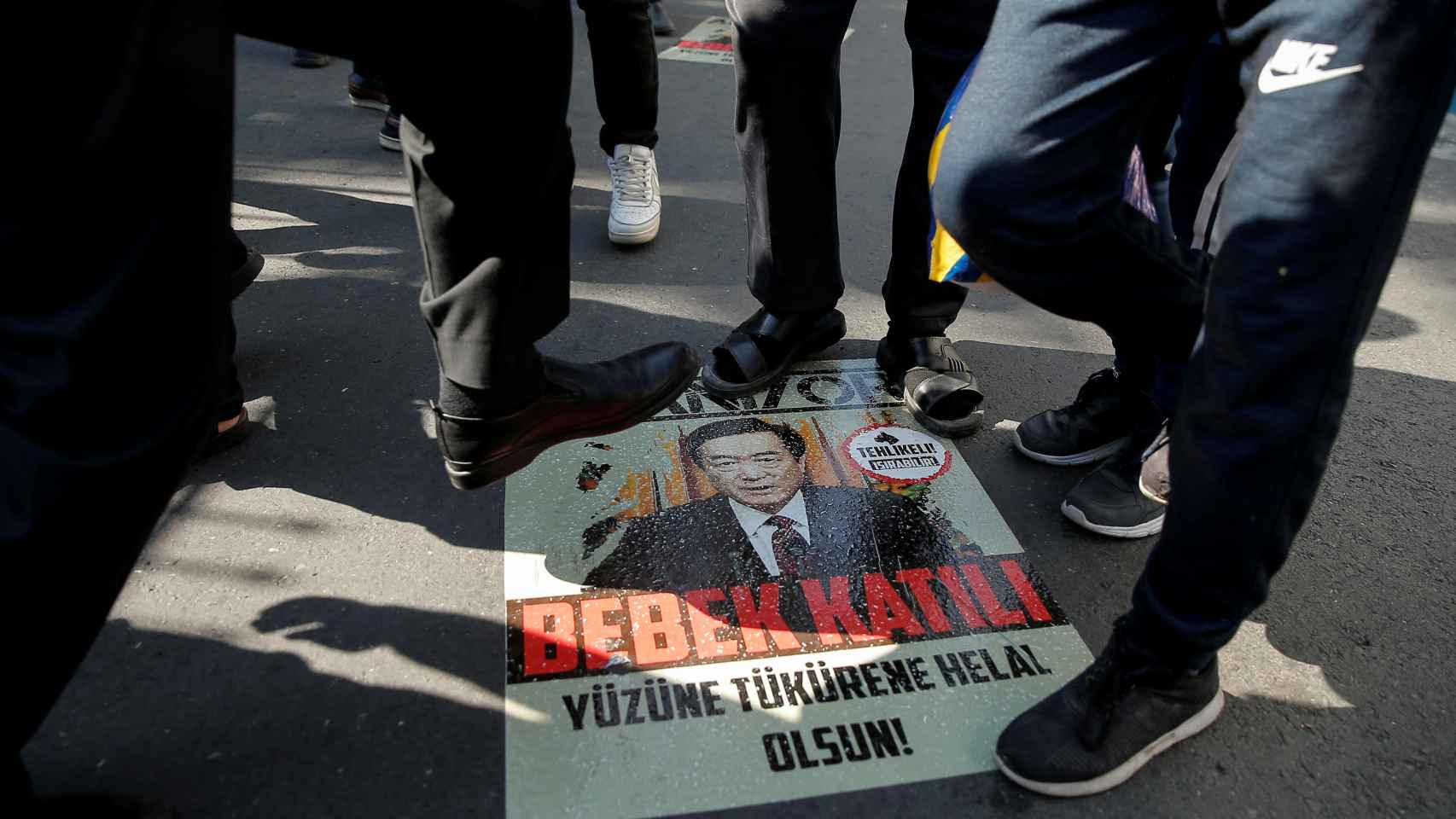 Protestas de uigurs contra el gobierno chino pisan la imagen del presidente Xi Jinping