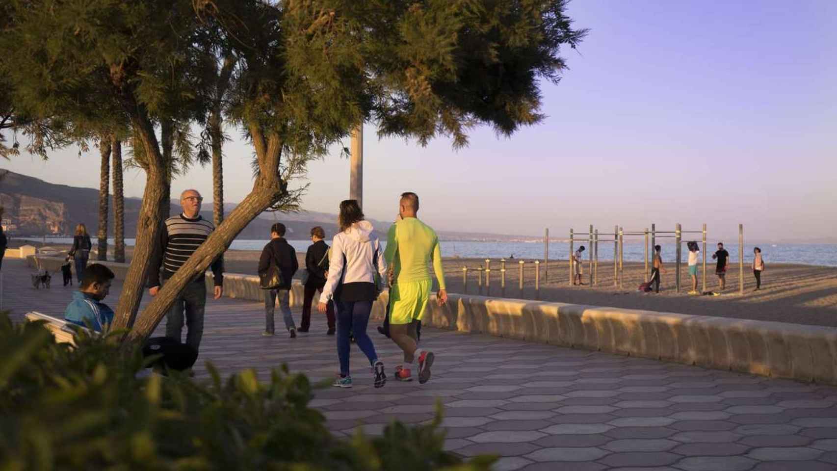 Unos vecinos paseando por el paseo marítimo de Roquetas de Mar