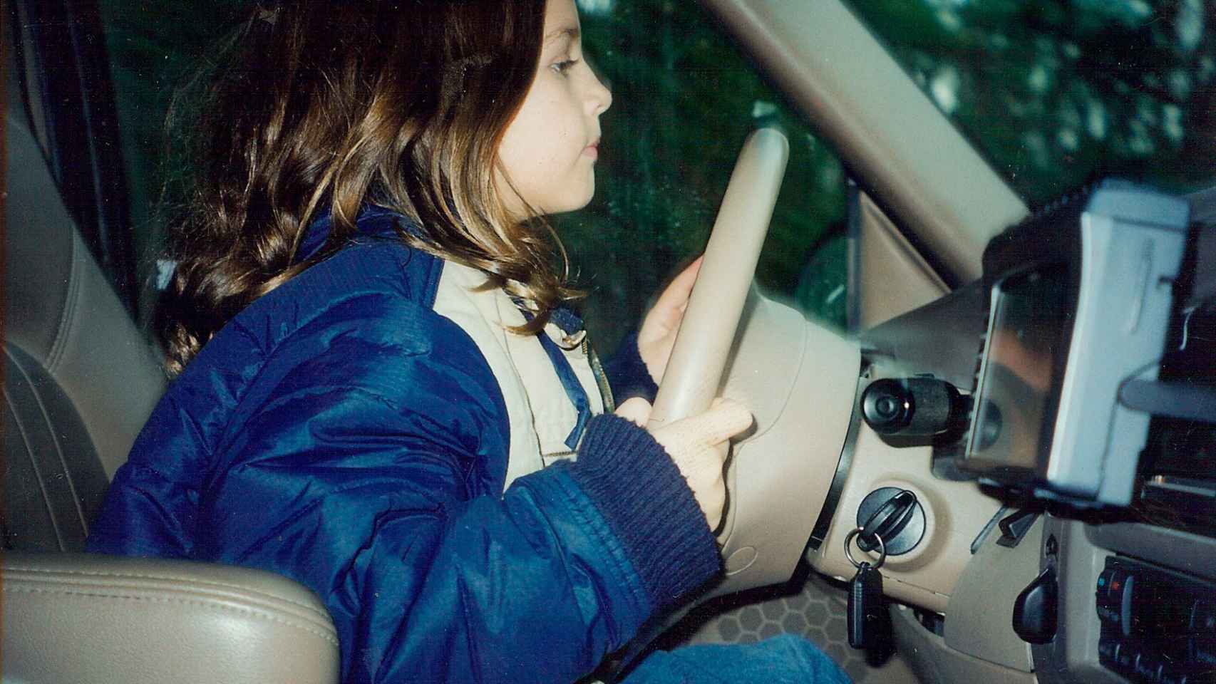 Cristina Gutiérrez, de pequeña, al volante de un coche.