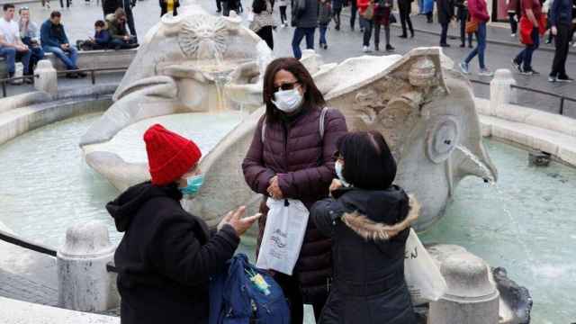 Un grupo de personas con mascarilla en una ciudad de Italia.