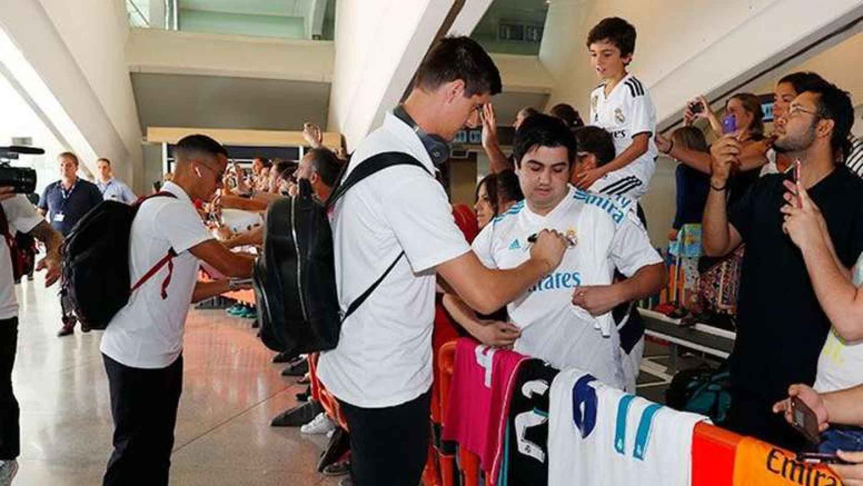 Thibaut Courtois firmando a un aficionado con la camiseta del Real Madrid.