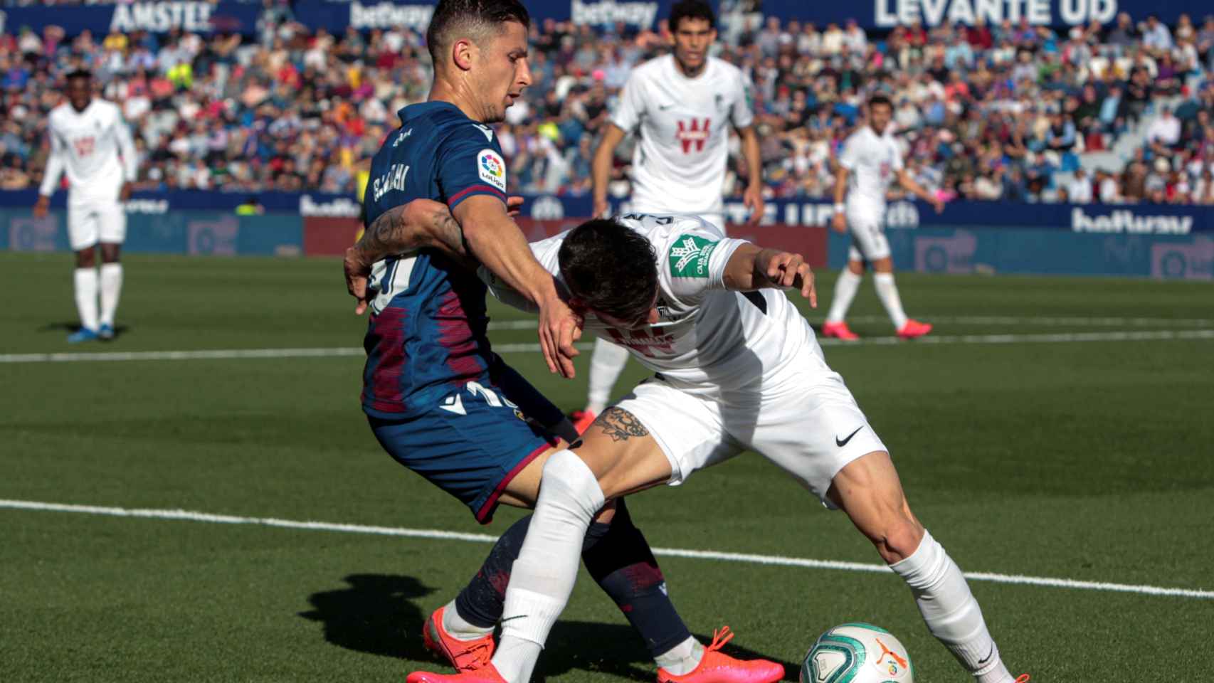 Jugadores de Levante y Granada disputando un balón en el encuentro liguero.