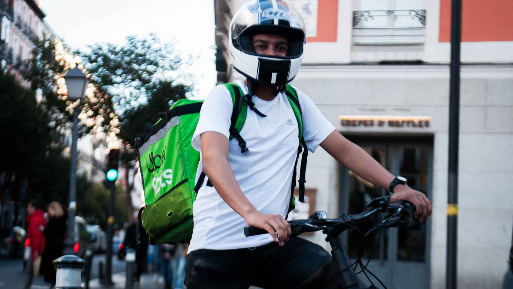 Alfredo, el único repartidor con bici que lleva casco de moto, según sus compañeros.