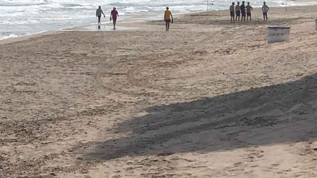 Un grupo de turistas jóvenes jugando un partido de voley en una playa de La Manga este viernes.