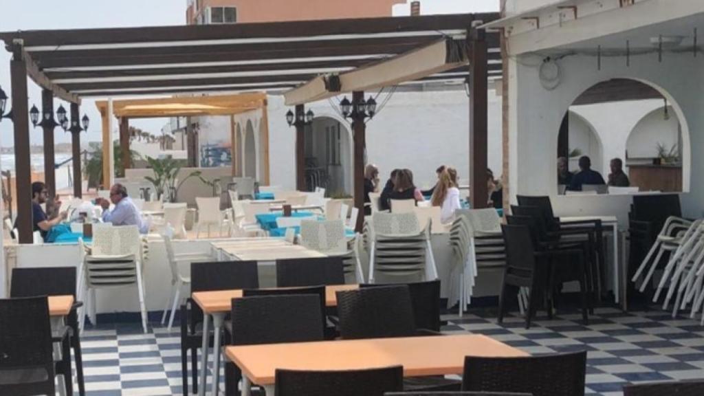 Turistas madrileños disfrutando este viernes de una comida en un chiringuito en primera línea de playa en La Manga.