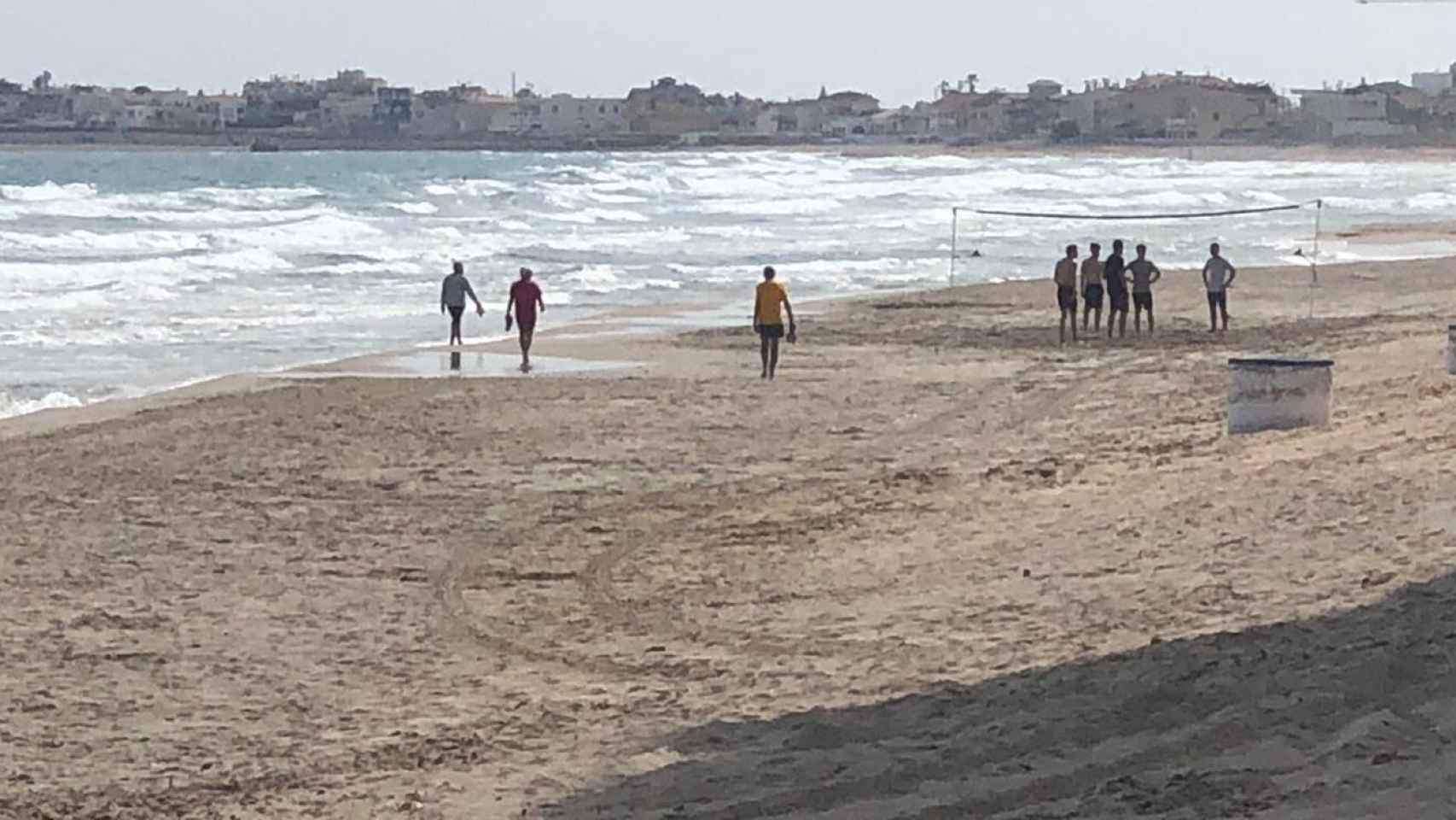 Un grupo de turistas jóvenes jugando un partido de voley en una playa de La Manga este viernes.