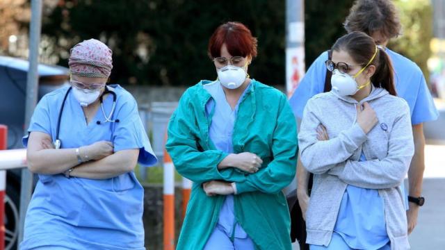 Personal médico saliendo de un centro hospitalario.