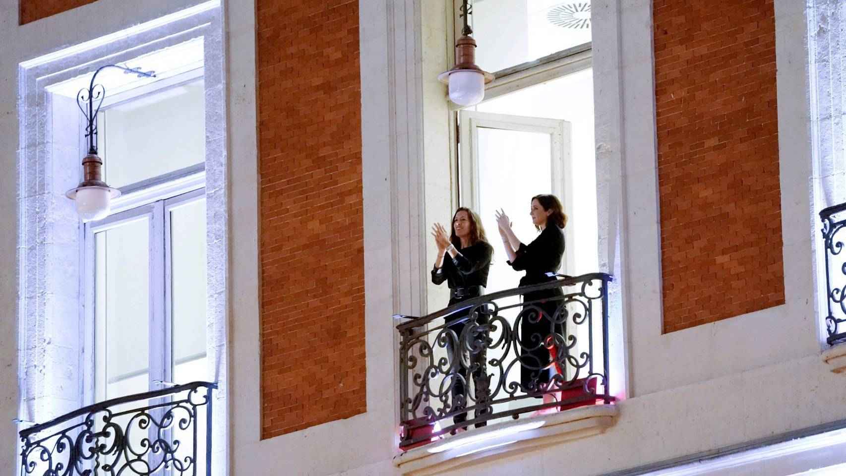 Isabel Díaz Ayuso aplaude a los sanitarios desde un balcón de la sede de la Comunidad de Madrid.