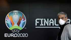 El logo de la Eurocopa 2020 y un empleado de UEFA con mascarilla
