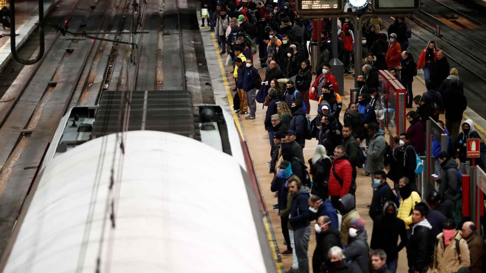 Decenas de usuarios cogen un tren de Cercanías a primera hora de este martes en Atocha.