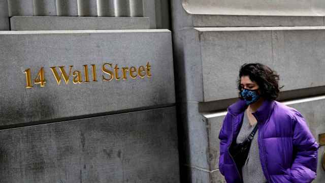Una mujer pasea ante un indicador de Wall Street.