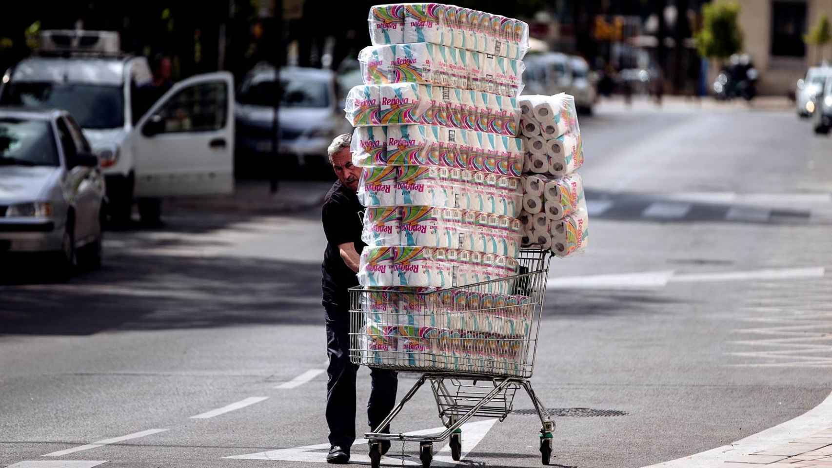 Un hombre compra rollos de papel higiénico en un supermercado.