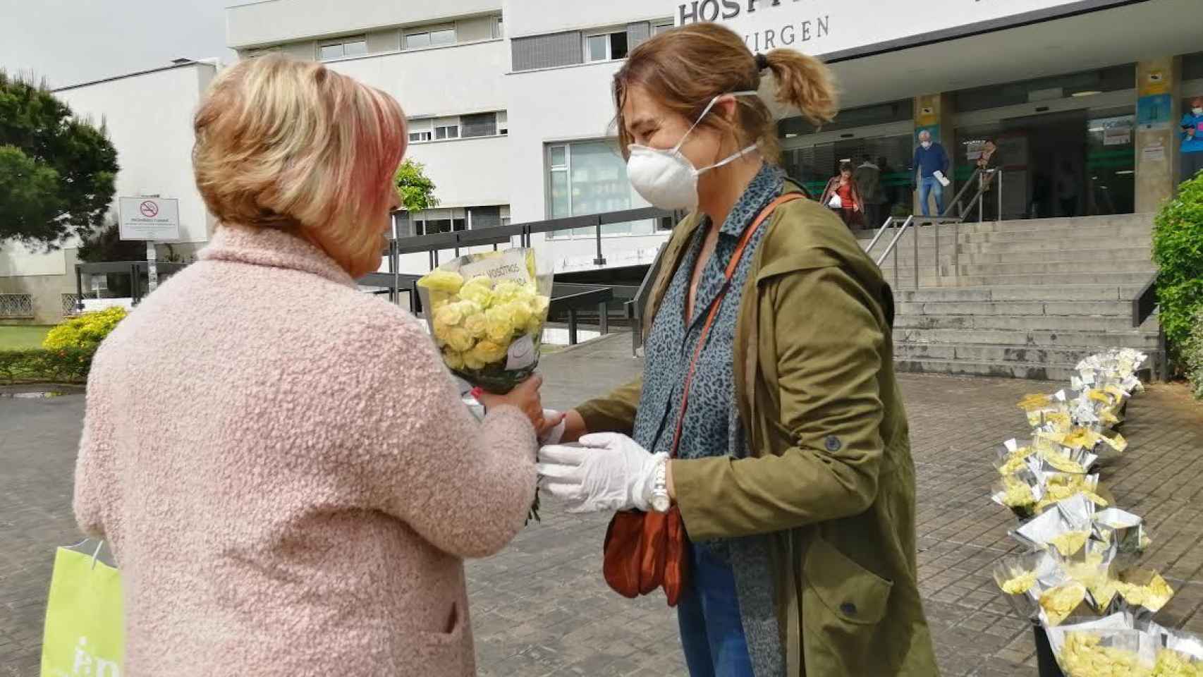 Rocío Gómez (derecha), regala un ramo de rosas de pitiminí a la sanitaria Dolores Ubri, este viernes, en Sevilla.