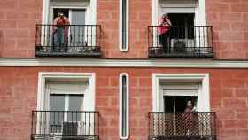 Varias mujeres, con sus cacerolas, en los balcones de sus casas.