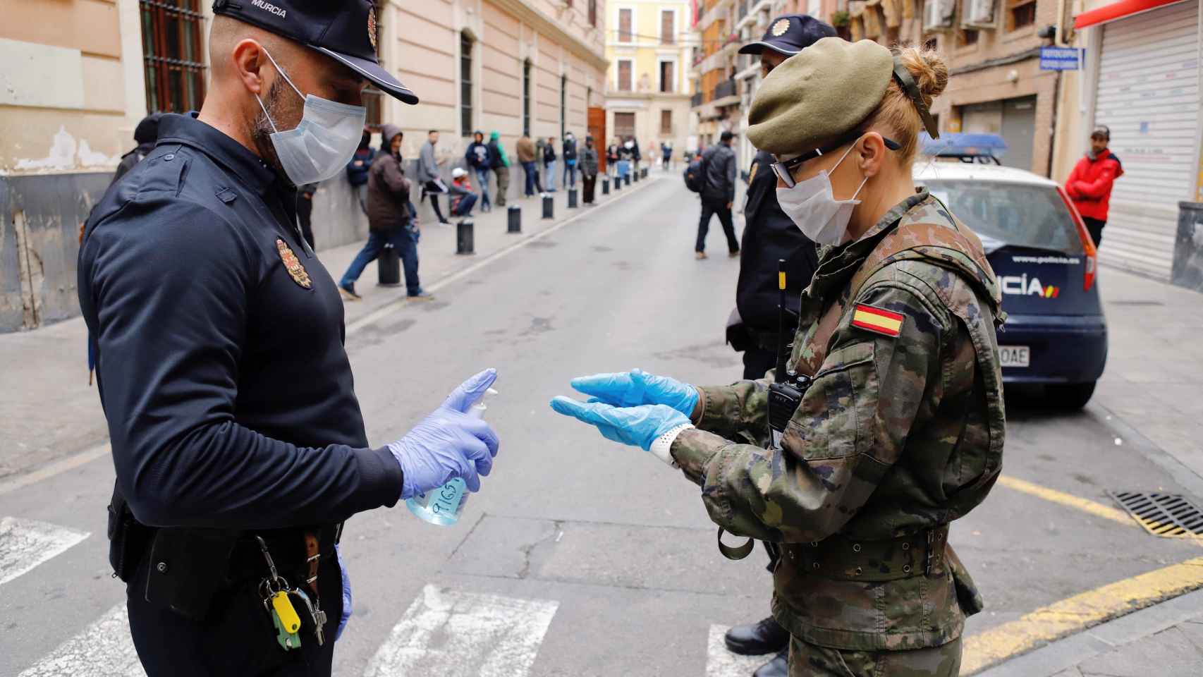Un policía local de Murcia ofrece gel desinfectante a una militar del Ejército de Tierra.
