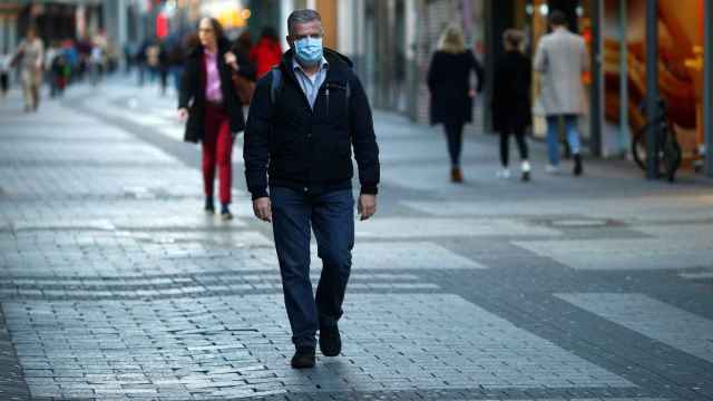 Un hombre camina por la calle con mascarilla en la ciudad de Colonia.