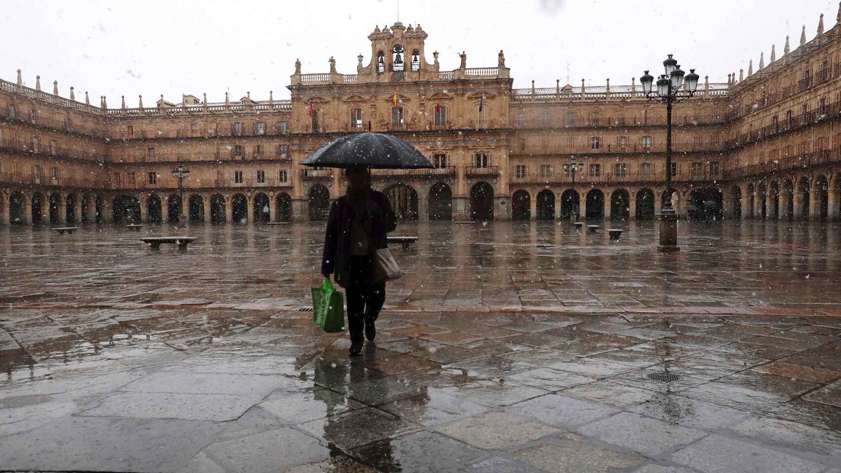 Una mujer camina solitaria por la plaza Mayor de Salamanca. EFE. J. M. García.