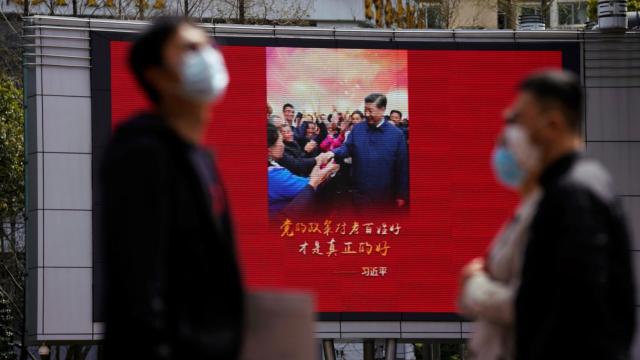 Ciudadanos delante de una pantalla con el presidente de China, Xi Jinping