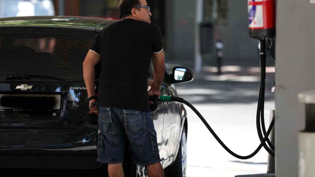 Un señor repostando gasolina.