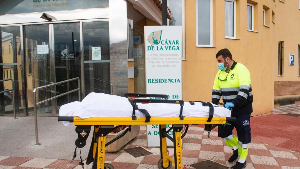 Personal sanitario traslada una camilla en la residencia de mayores de Cájar (Granada) donde varios ancianos han fallecido en los últimos días.