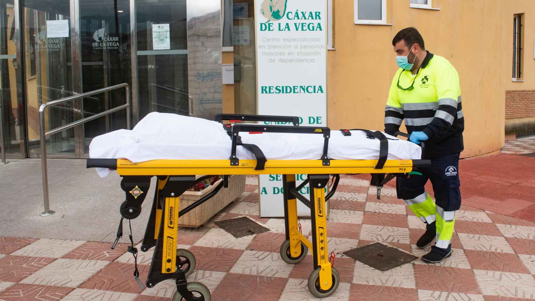 Personal sanitario traslada una camilla en la residencia de mayores de Cájar (Granada) donde varios ancianos han fallecido en los últimos días.