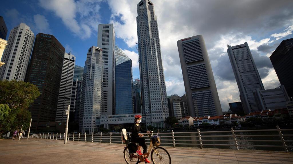 Un ciclista frente al área del Distrito Central de Negocios (CBD) en Singapur, 03 de abril de 2020.