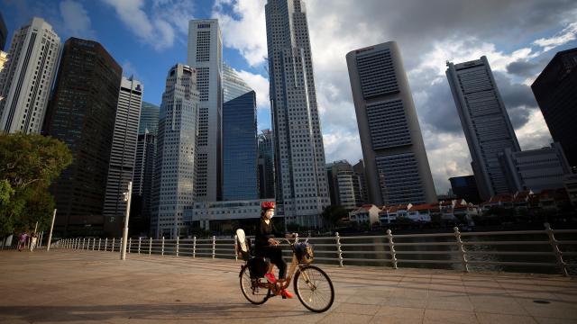 Un ciclista frente al área del Distrito Central de Negocios (CBD) en Singapur, 03 de abril de 2020.