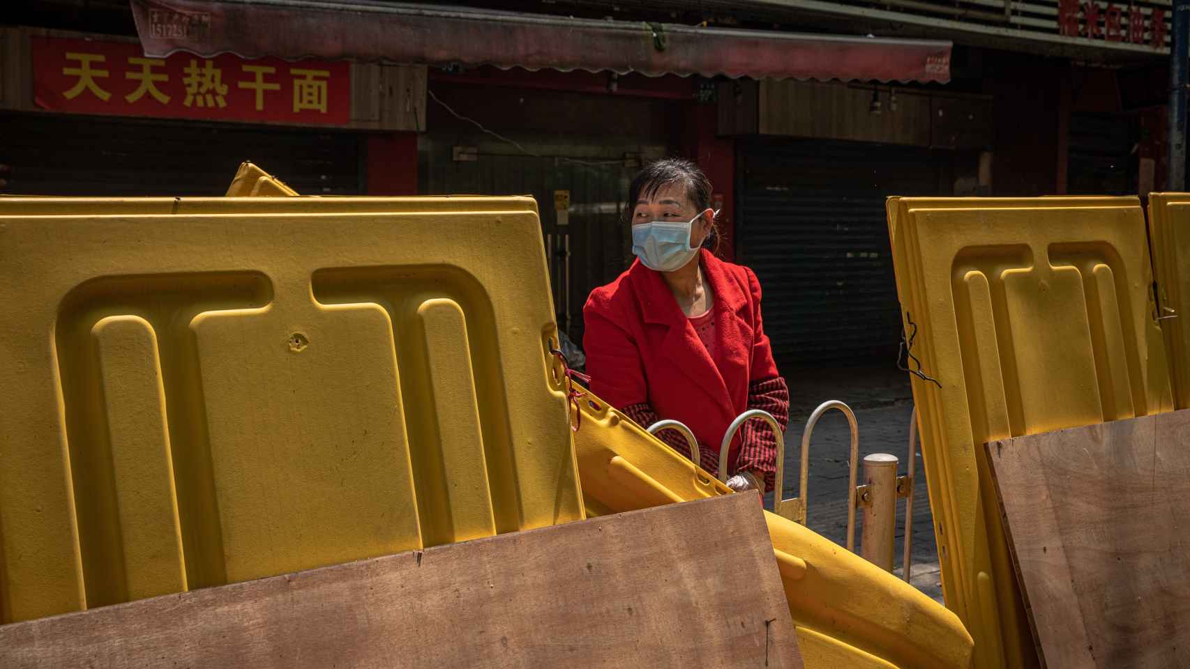Una ciudadana de Wuhan, tras una de las vallas que se situaron entre barrios.