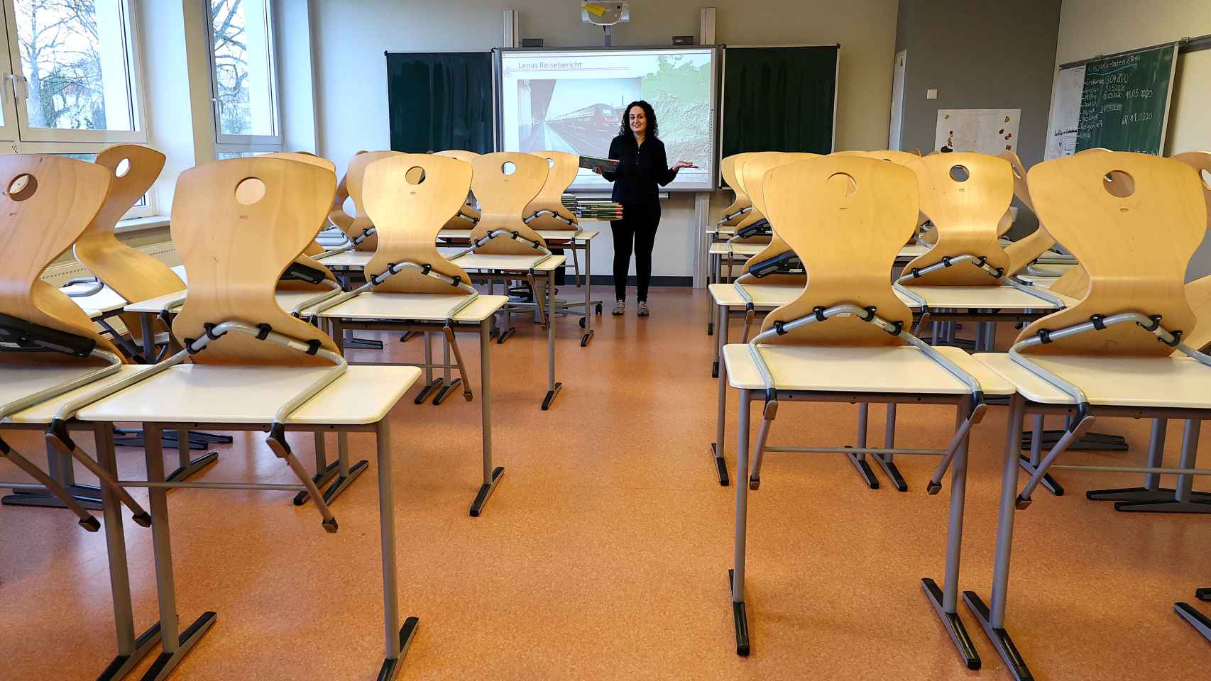 Una profesora da clases virtuales ante un aula vacía.