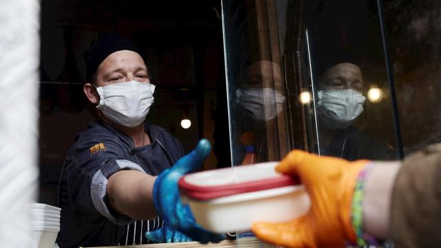 El cocinero Adrián Rojas reparte comida en su restaurante, reconvertido en comedor solidario, en Madrid. EFE/ Ana Márquez.