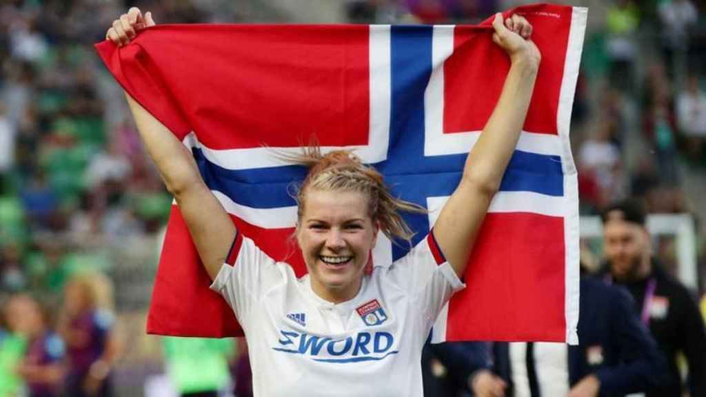 Ada Hegerberg, con la bandera de Noruego celebrando un título del Olympique de Lyon