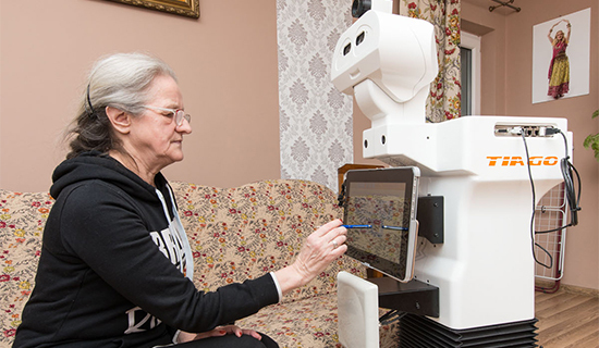 El robot Tiago de Pal Robotics, asistiendo a una mujer mayor en su hogar. Foto: Pal Robotics