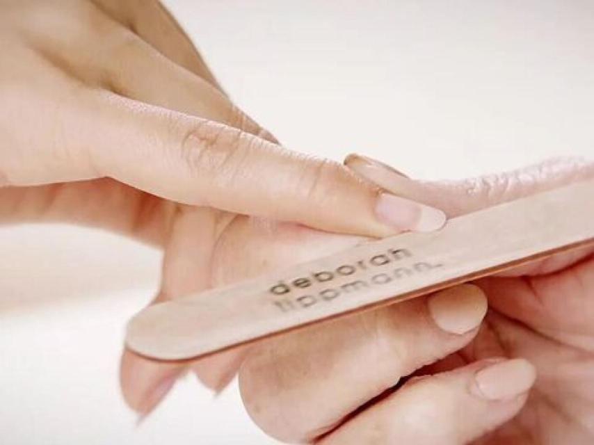 Modelo limándose las uñas.