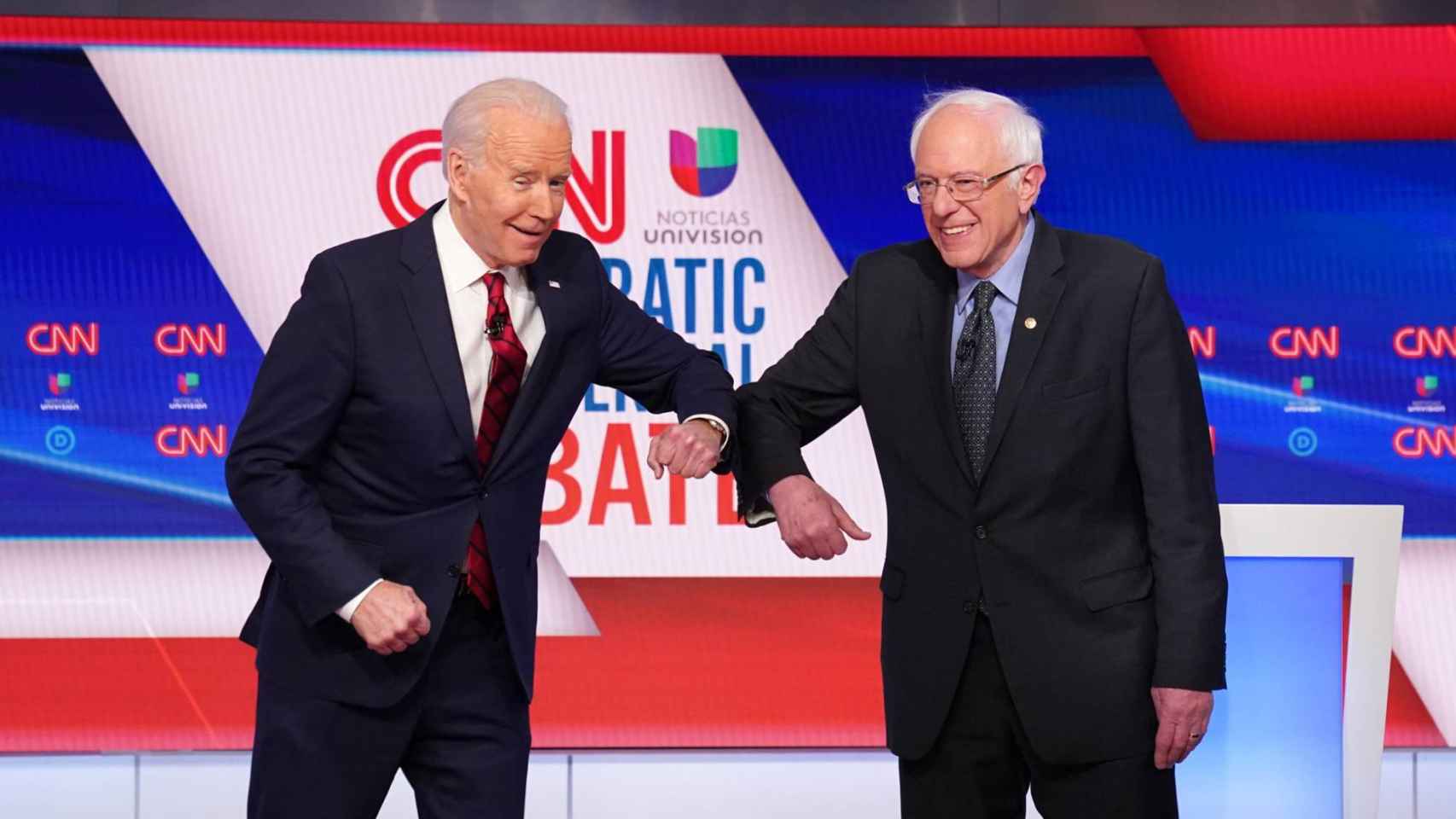 Joe Biden y Bernie Sanders se saludan con el codo tras su debate por las primarias.