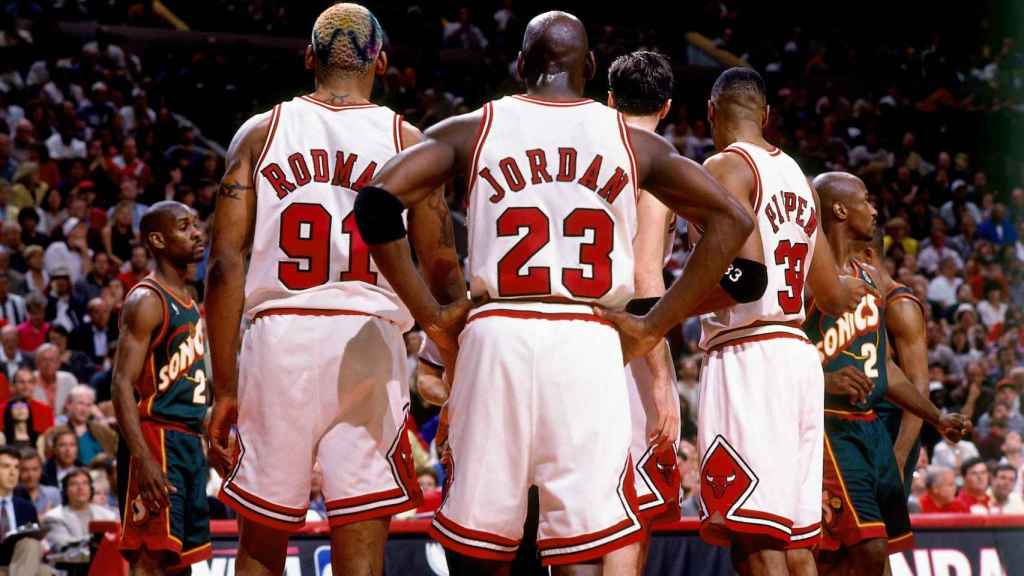 Michael Jordan, Dennis Rodman y Scottie Pipen escuchando las órdenes de Phil Jackson