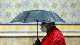 Un hombre se protege de la lluvia este 15 de abril, el trigésimo segundo día del estado de alarma.