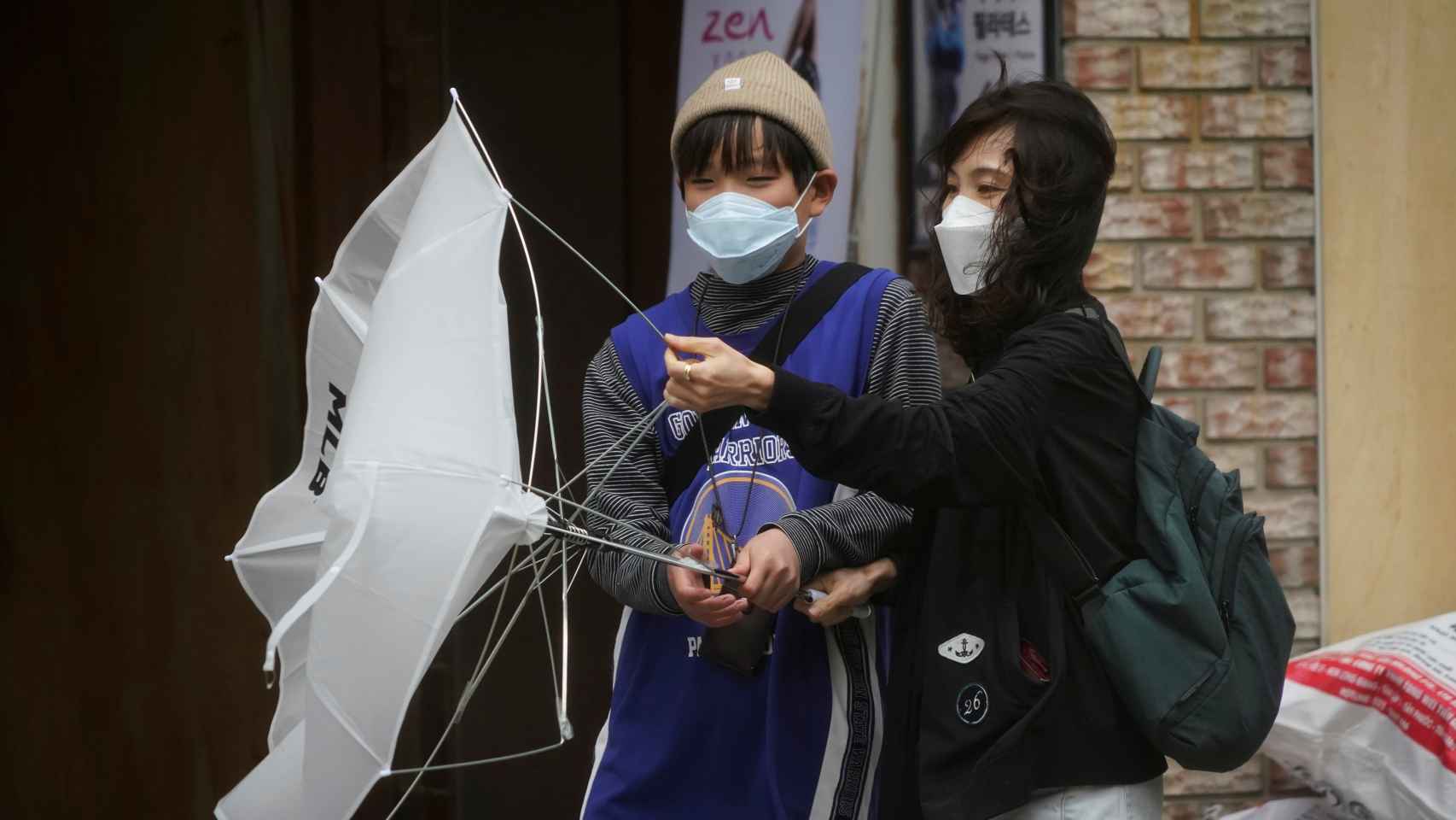 Dos mujeres luchan contra el viento en Corea del Sur.