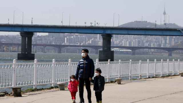Unos niños pasean con uno de sus padres en Corea del Sur.