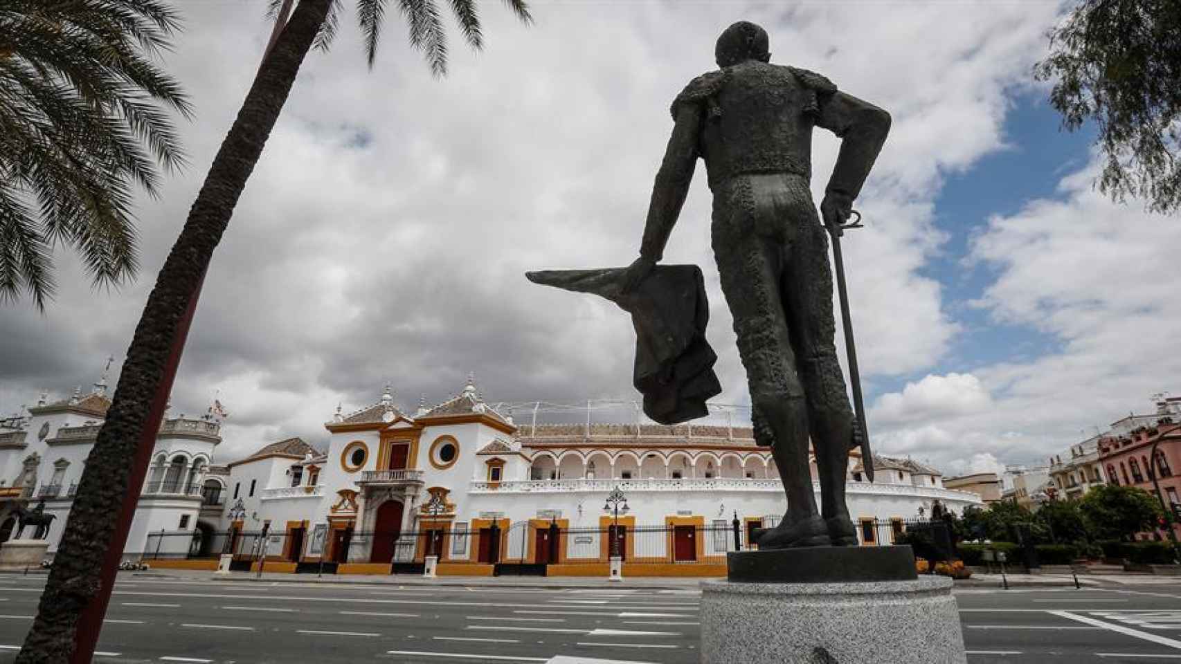 Plaza de toros de la Real Maestranza de Sevilla desde la escultura del diestro Pepe Luis Vázquez en un Paseo de Colón vacío.