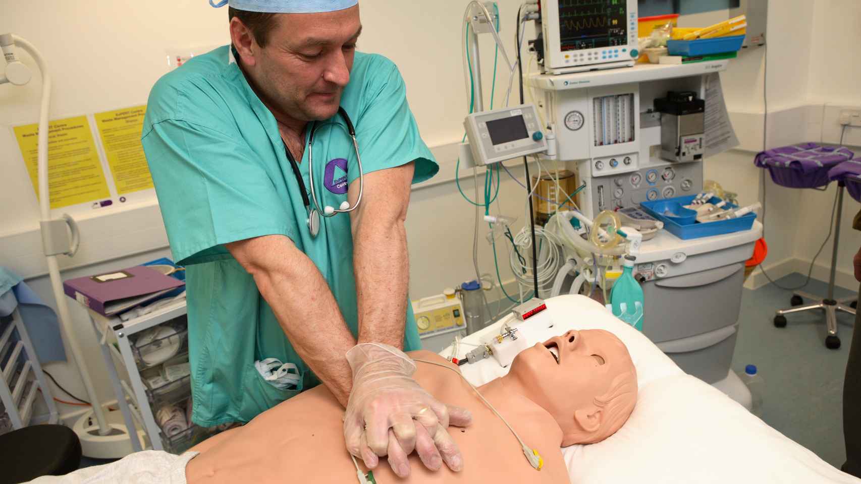 Un sanitario practicando un masaje cardíaco con un muñeco.