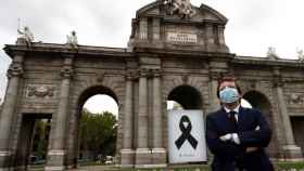 Madrid recuerda a los muertos por coronavirus con un crespón en la Puerta de Alcalá