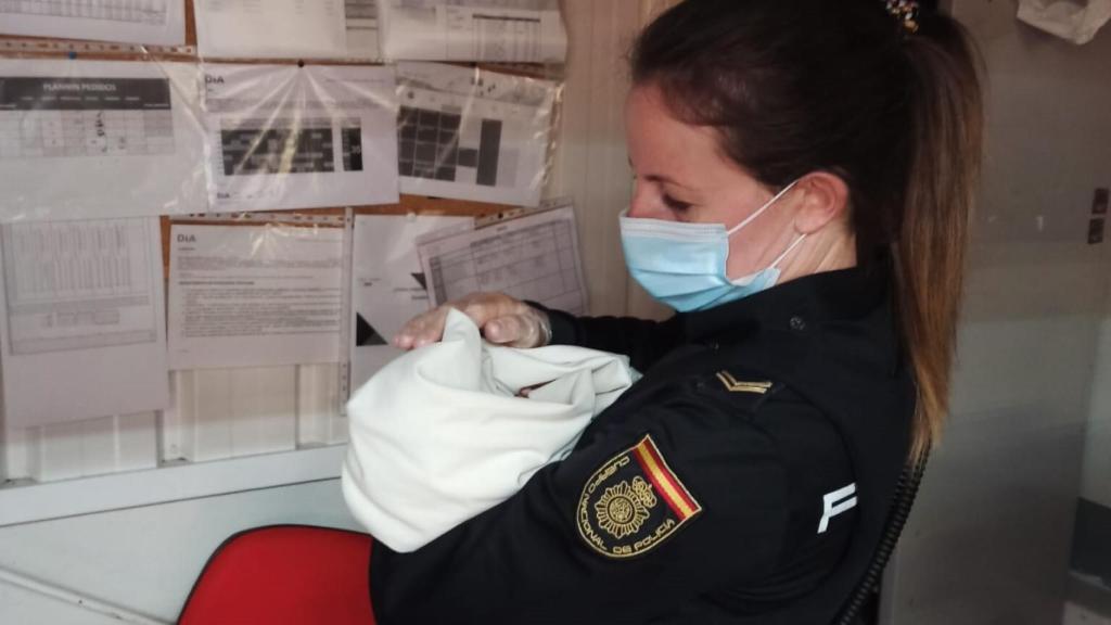 Una agente de Policía con el bebé encontrado en un supermercado de Ávila en brazos.